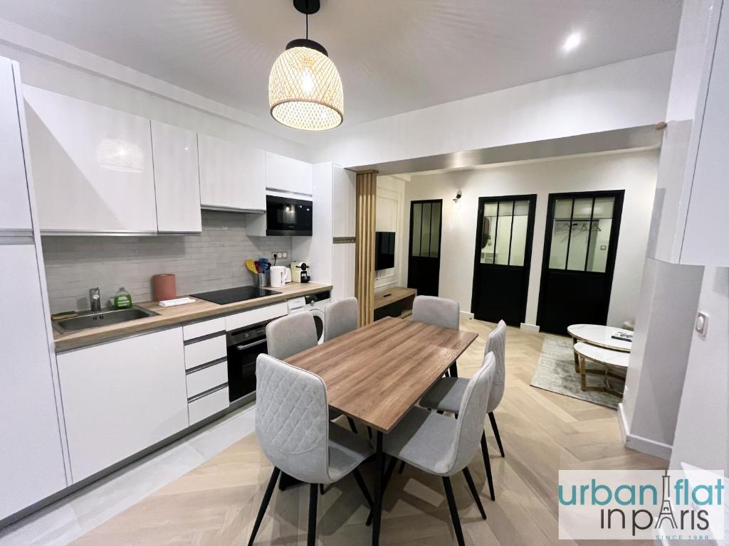 une cuisine et une salle à manger avec une table et des chaises en bois dans l'établissement Urban Flat 178 - Cosy Chic 2 Bedroom Flat in Paris, à Paris