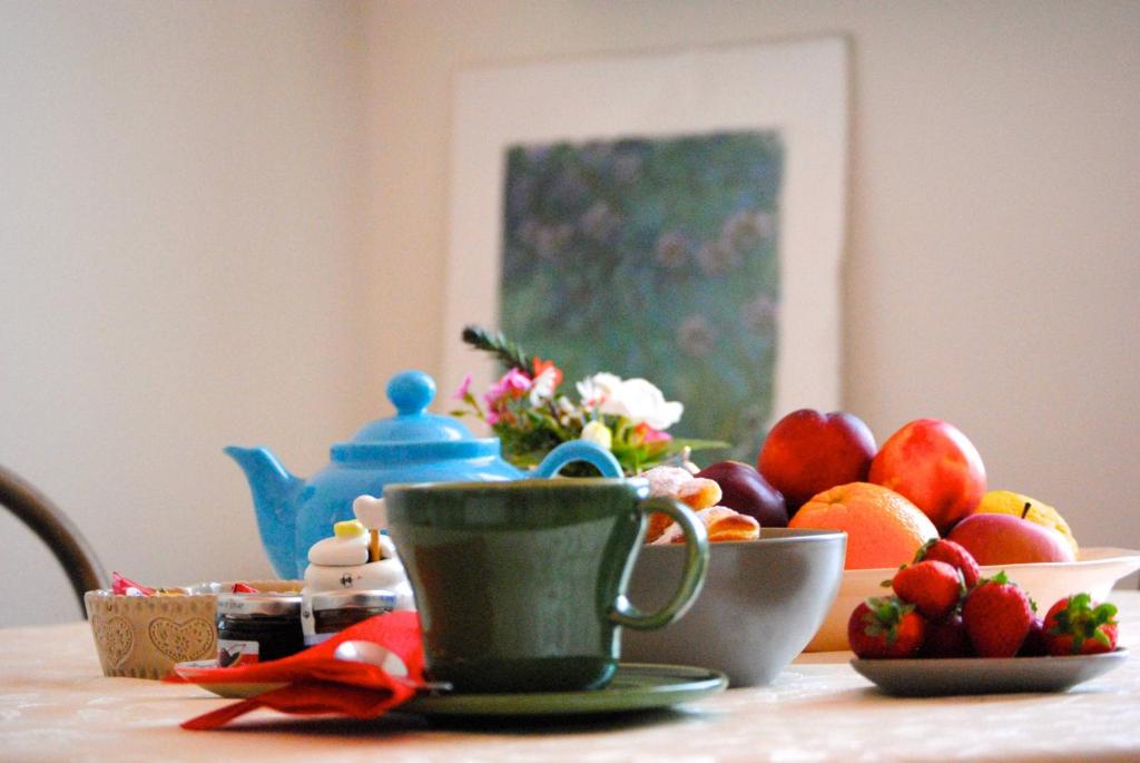 a table with a cup of tea and fruit on it at B&B Agapantus in una Villa dell'800 in Dolceacqua