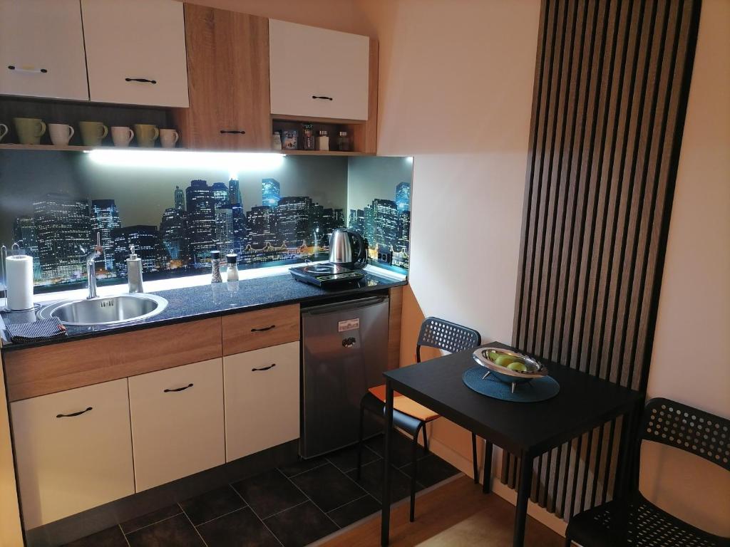 a small kitchen with a sink and a table at Harmony downtown apartment in Šabac