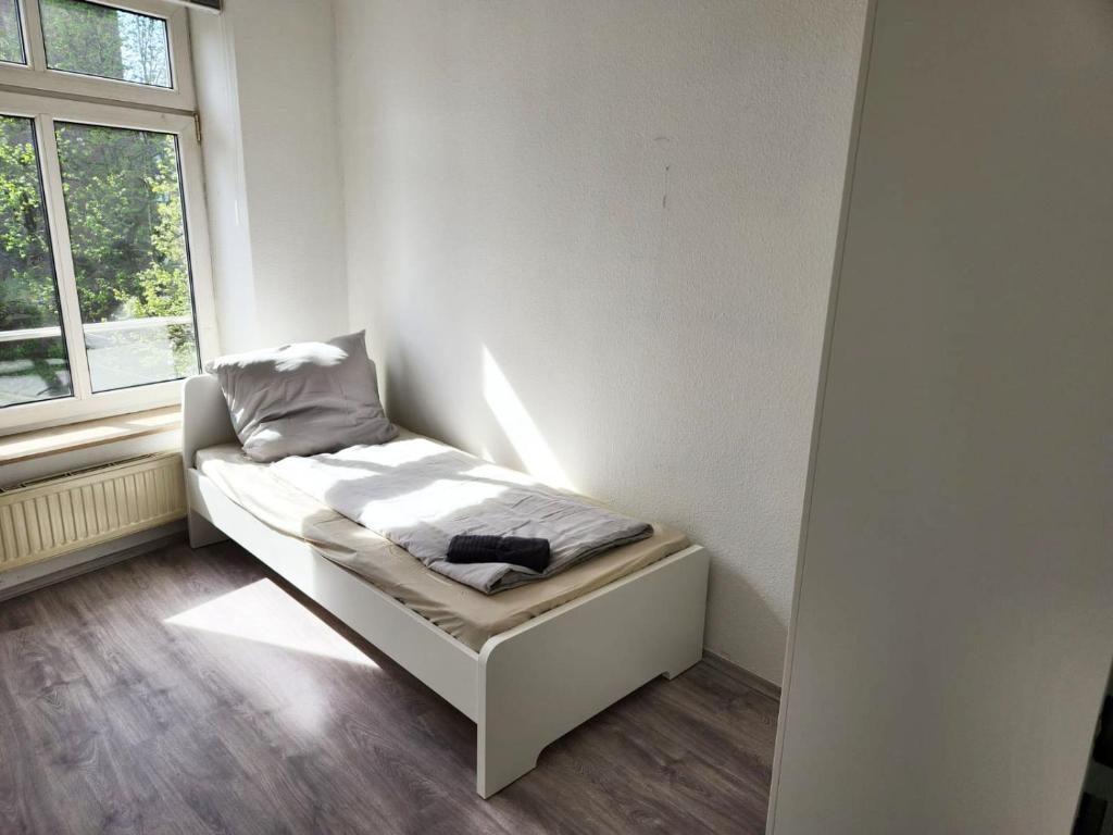 a small bed in a room with a window at Work & Stay Apartments in Stolberg in Stolberg