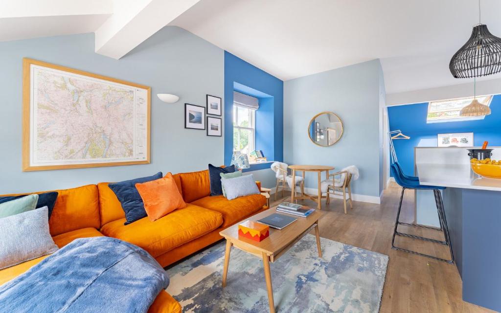 een woonkamer met een oranje bank en een tafel bij Swallow in Bowness-on-Windermere
