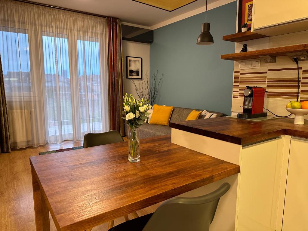 uma cozinha com uma mesa com um vaso de flores em Cherry Abode Apartment with Terrace em Budapeste
