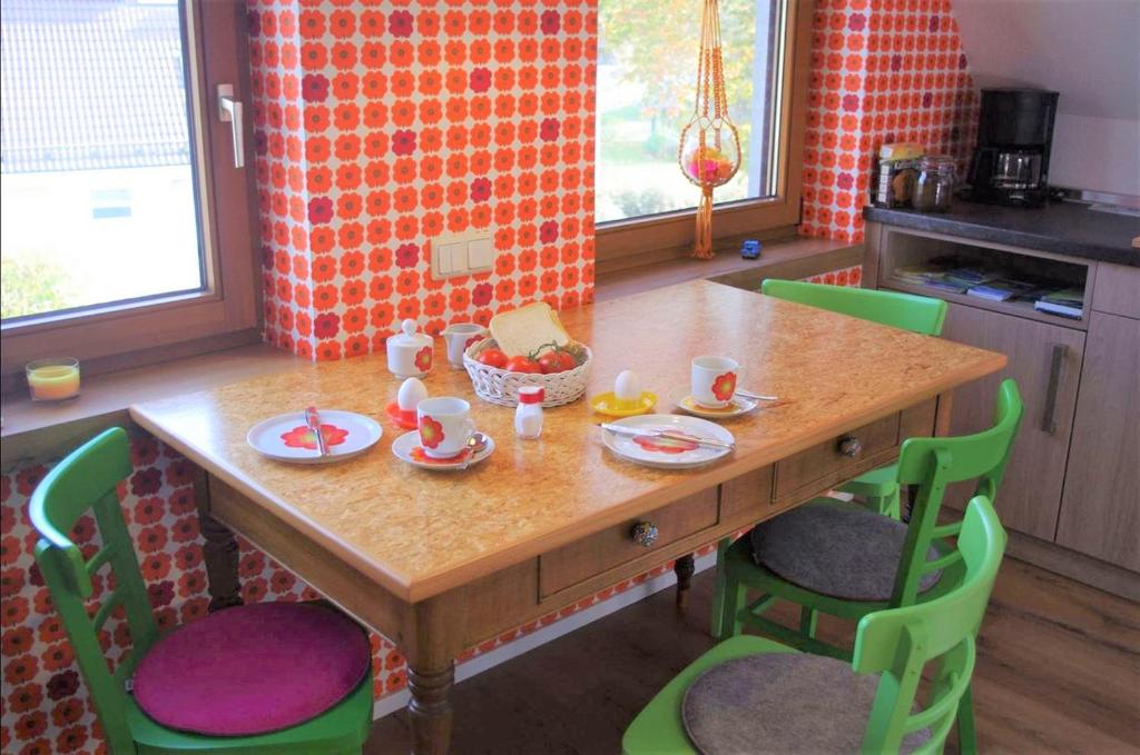 a wooden table with chairs and a table with food on it at Schmitzebrinks Ferienwohnung in Kierspe