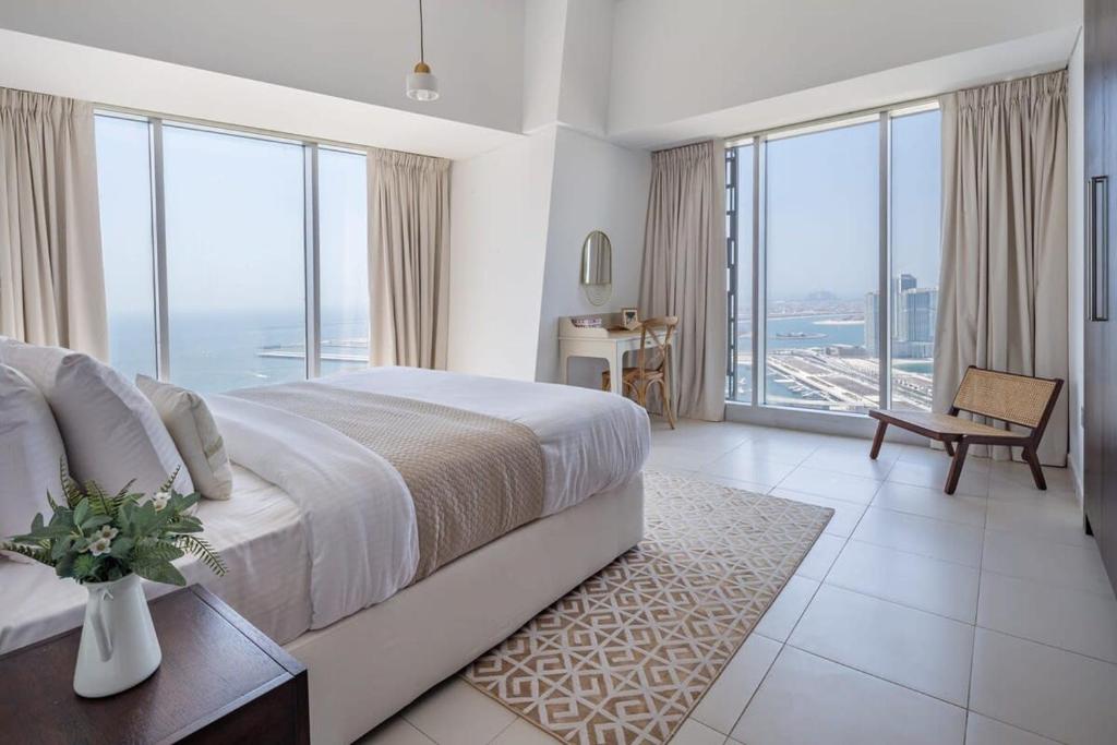 a bedroom with a large bed and large windows at Frank Porter - Cayan Tower in Dubai