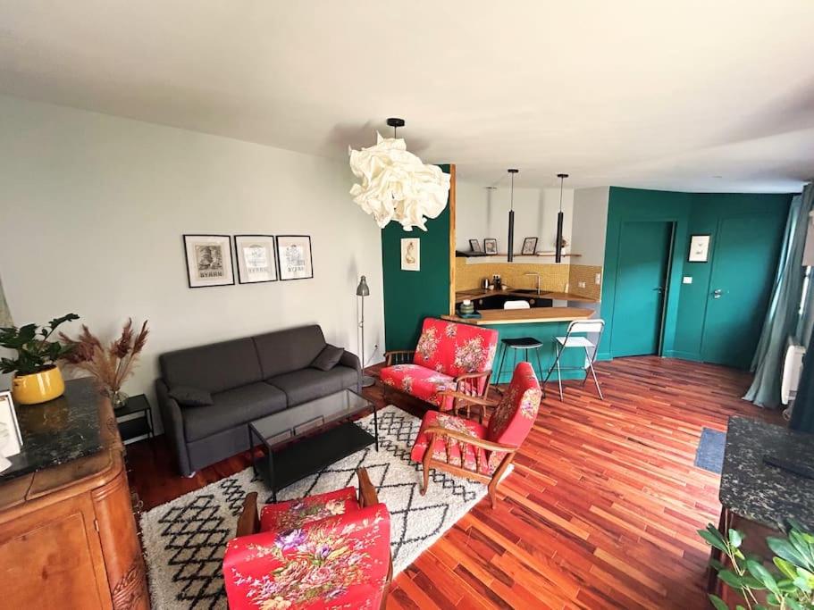 Maison T2 avec patio في لا روشيل: غرفة معيشة مع أريكة وكراسي حمراء