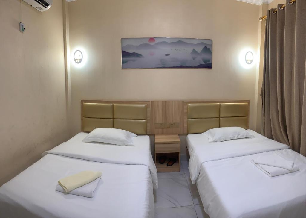 duas camas num pequeno quarto com dois ermottermott em 西港宾馆 em Sihanoukville
