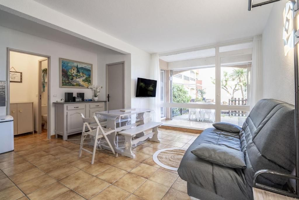 een woonkamer met een bank en een tafel bij Le Cap 27 in Cap d'Agde