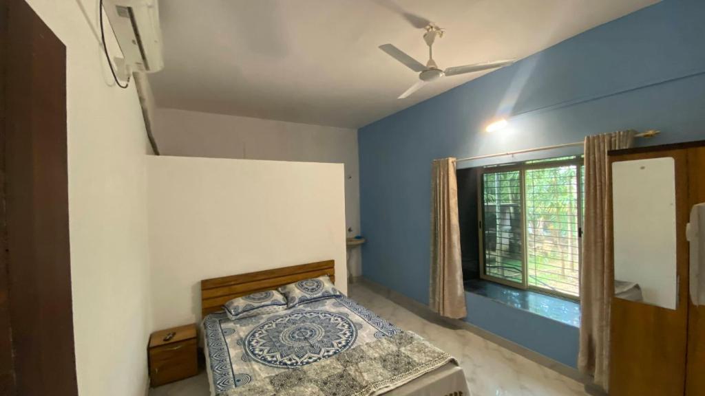 a bedroom with a bed and a window at Sonchafa Stays in Nagaon