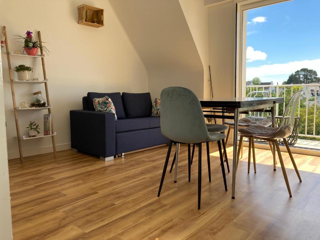 - un salon avec une table et un canapé dans l'établissement Bénodet Centre - Triplex - 4 pers, à Bénodet