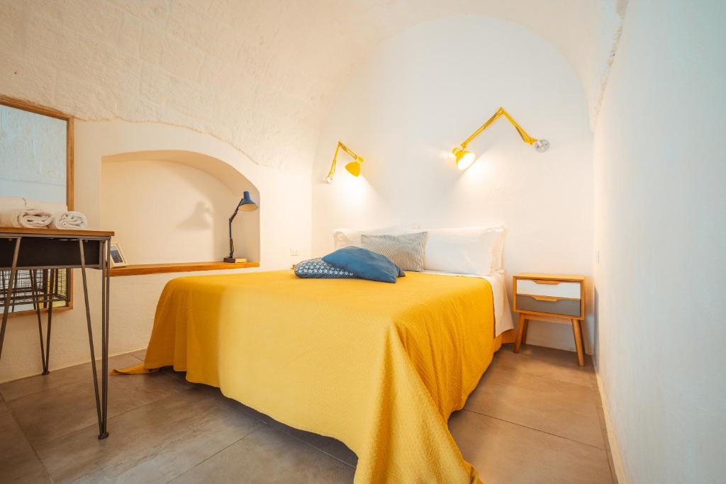 sypialnia z żółtym łóżkiem z 2 poduszkami w obiekcie Poseidonia-Housea Travel w mieście Polignano a Mare