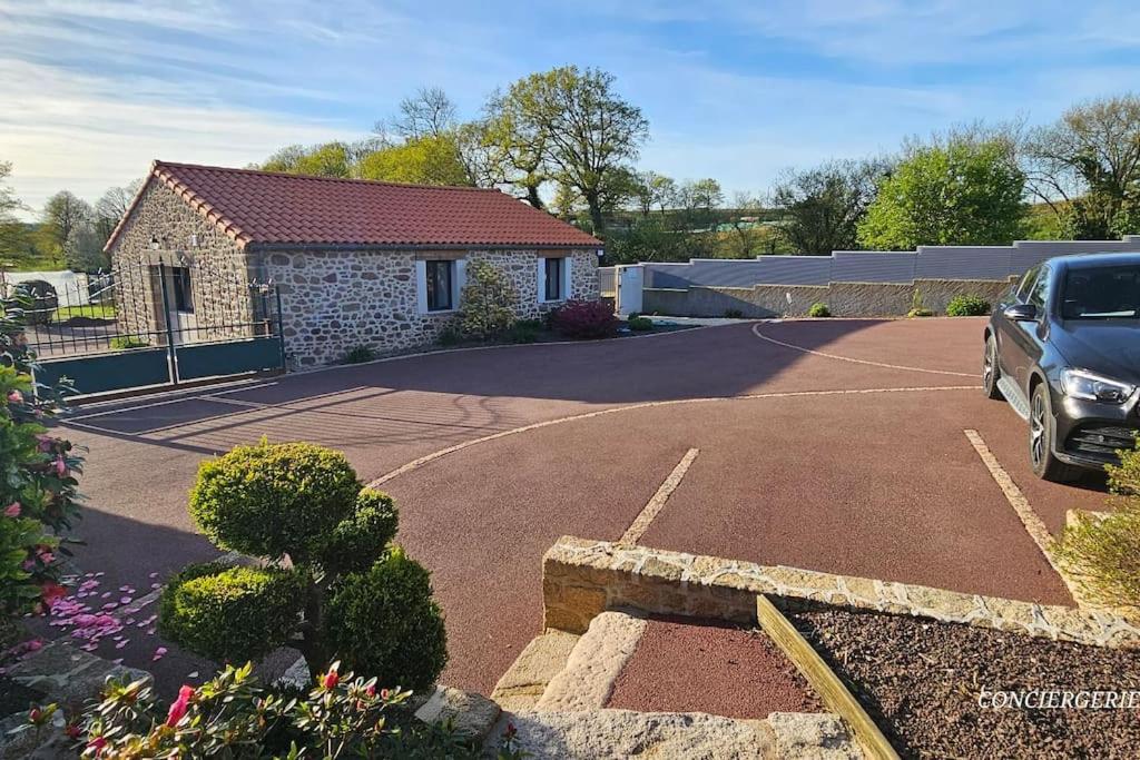 une voiture garée dans un parking à côté d'une maison dans l'établissement La P'tite Crume joli gîte à 5 min du Puy du Fou, à La Verrie