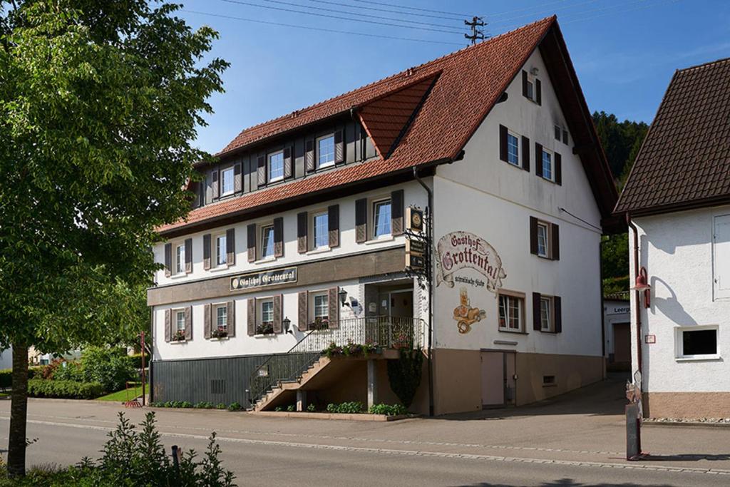 a large white building with a red roof at Hotel Garni Grottental in Meßstetten