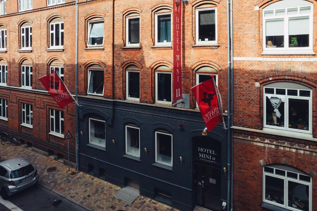 duas bandeiras vermelhas na lateral de um edifício em Milling Hotel Mini 11 em Odense