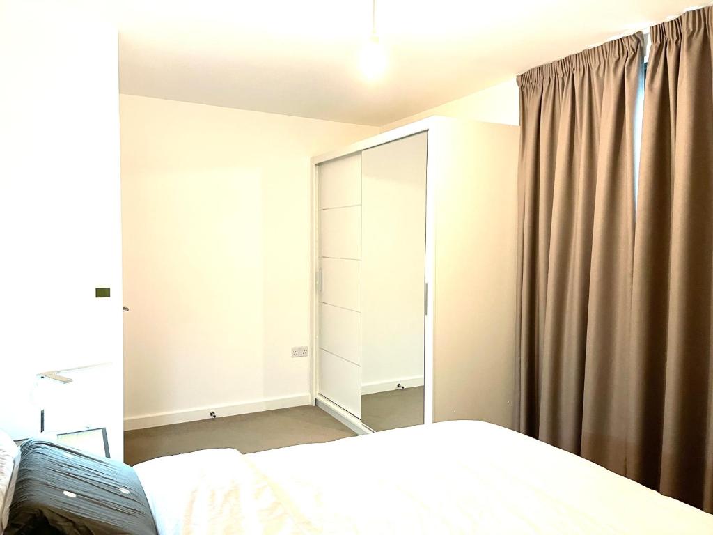um quarto com uma cama e um grande armário em Trendy king size bedroom em Sutton