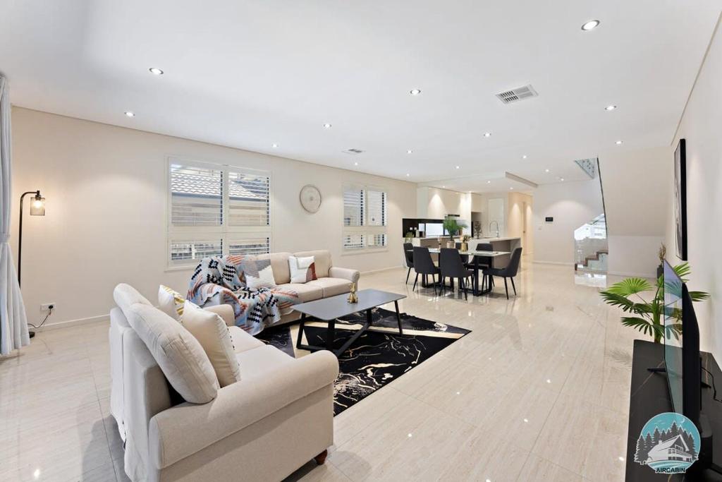 un soggiorno con mobili bianchi e una sala da pranzo di Aircabin - Eastwood - Luxury - 4 Bedrooms House a Eastwood