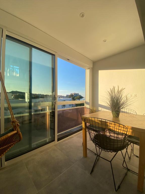卡爾維的住宿－DUPLEX CALVI DIRECT PLAGE，客房设有桌椅和大窗户。
