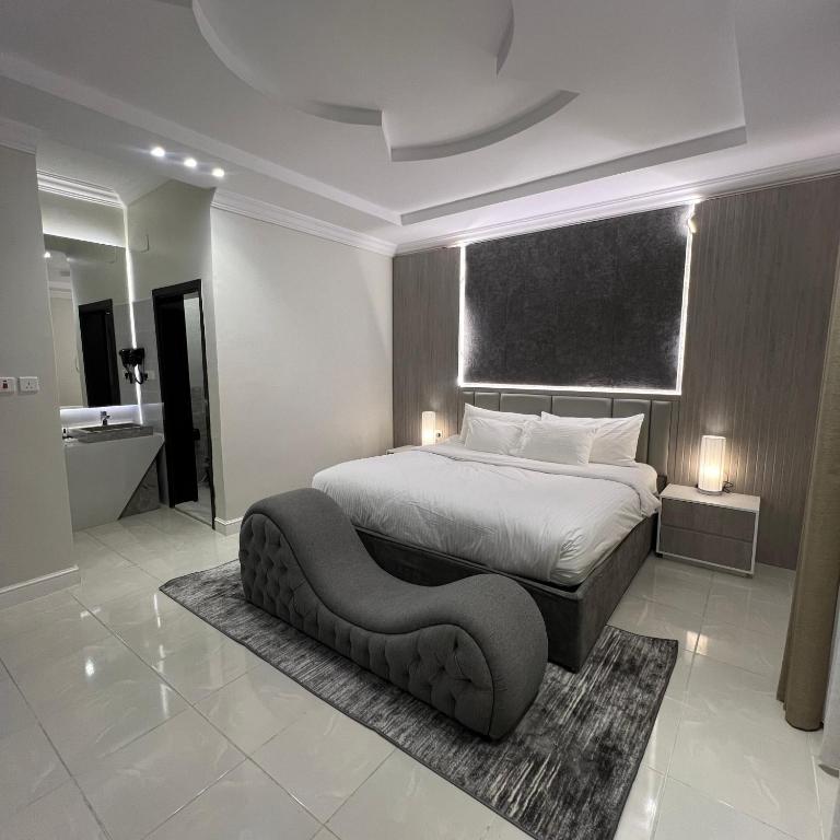 a bedroom with a large bed and a chair in it at شقق سنتارا الفندقية in Taif