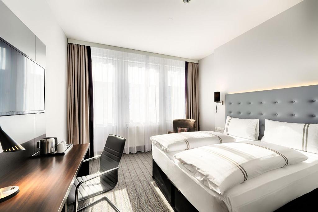 Premier Inn München City Ost في ميونخ: غرفة الفندق بسرير كبير ومكتب
