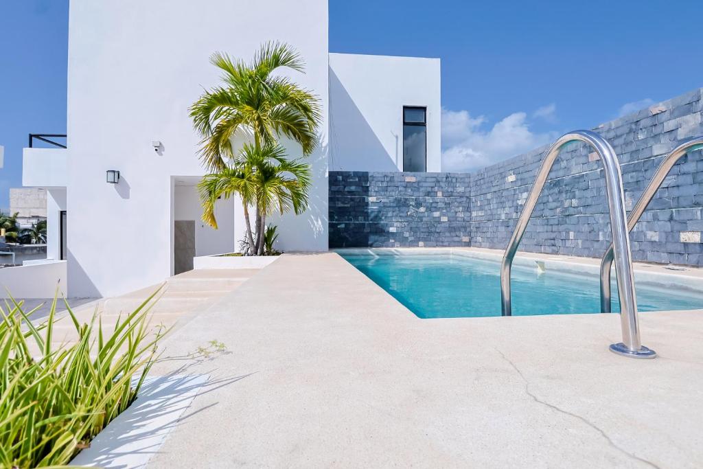 a swimming pool in a villa with palm trees at Arkana 9 Suites Grupo Amber - Collection O in Playa del Carmen