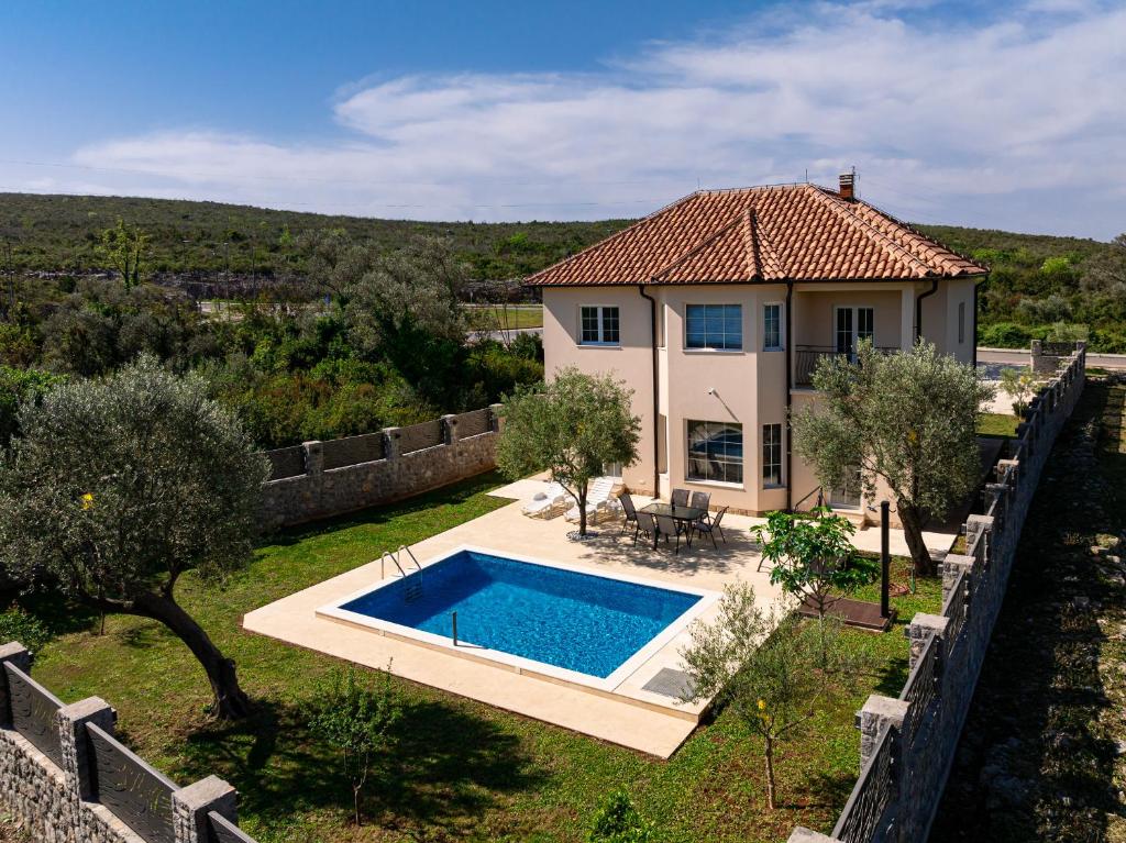 eine Villa mit einem Pool vor einem Haus in der Unterkunft Villa Stemi in Tivat