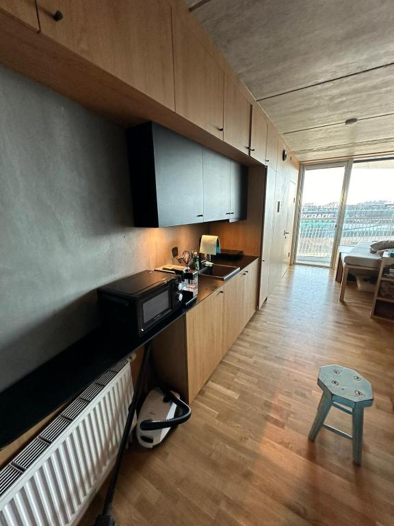 una cocina con armarios de madera y una mesa en una habitación en Central apartment Vesterbro, en Copenhague
