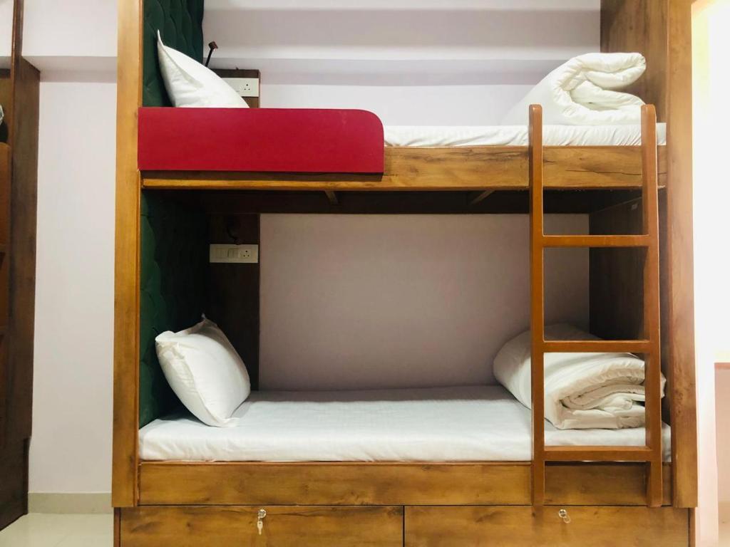 two bunk beds in a room with a red mattress at Everest Stays Rooms and Dormitory in Mumbai