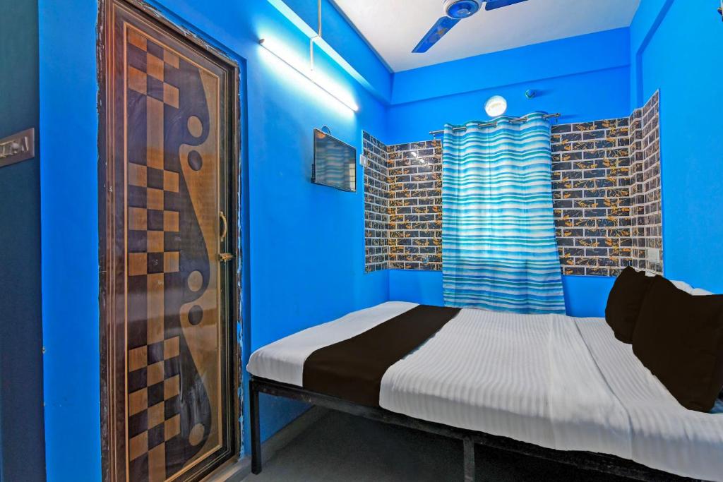 Camera blu con letto e finestra di OYO ANA GUEST HOUSE a kolkata