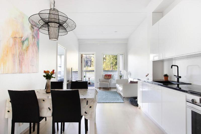 eine Küche und ein Wohnzimmer mit Tisch und Stühlen in der Unterkunft Kolmio Keskuspuiston lähellä in Espoo