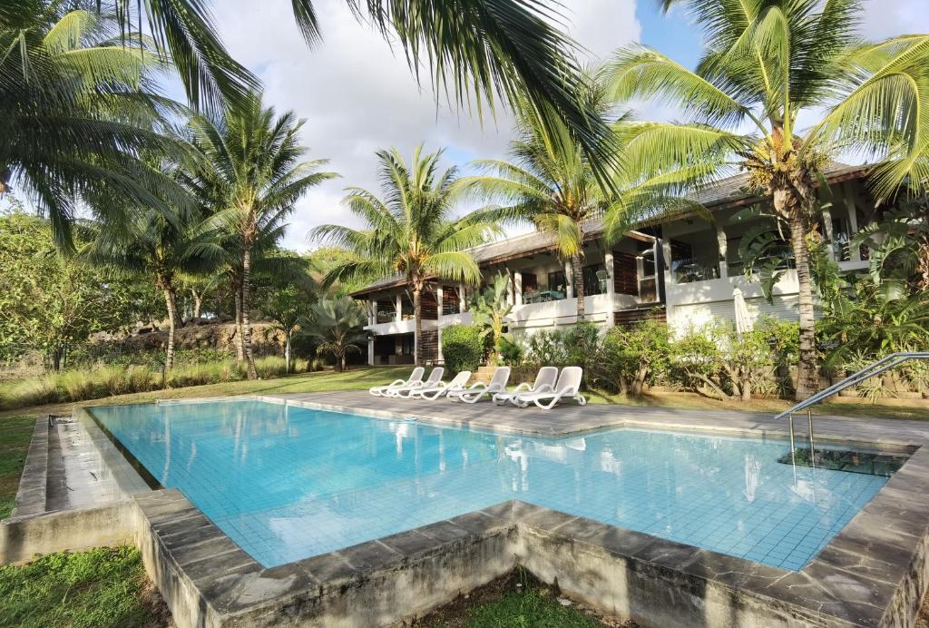 basen przed domem z palmami w obiekcie Appartement Terrasse du Barachois w mieście Tamarin