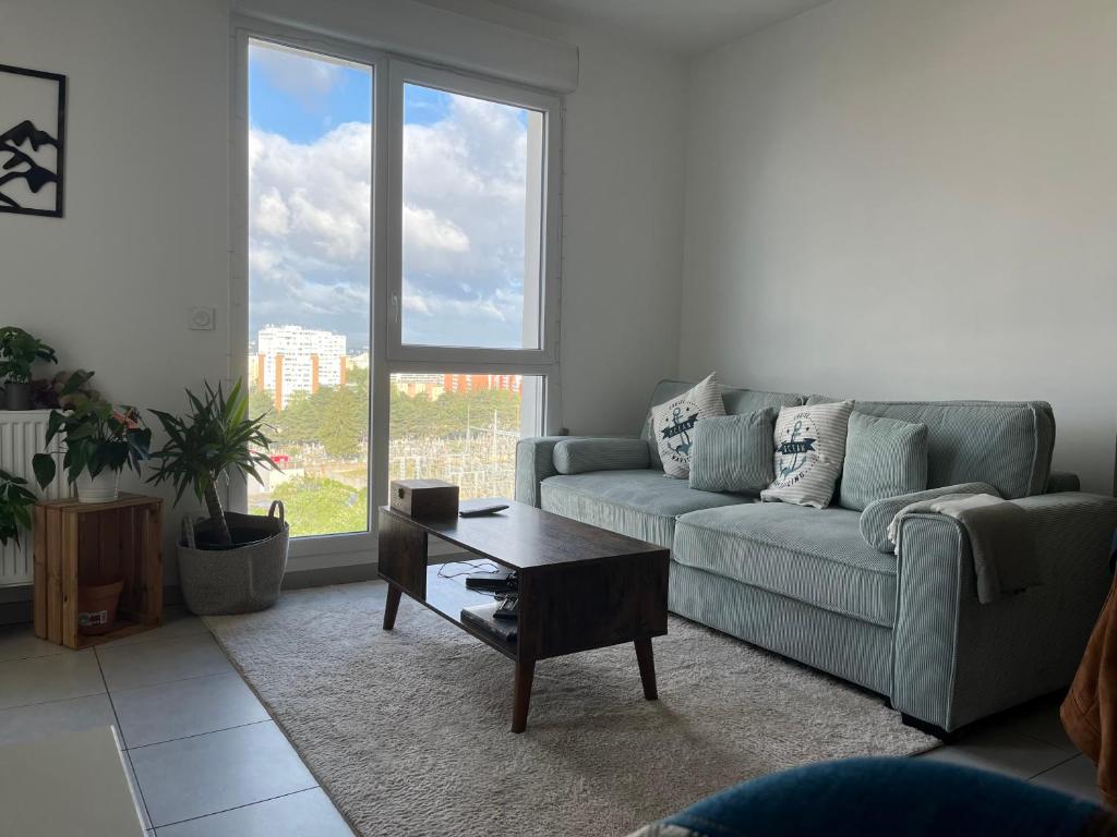 un salon avec un canapé et une table basse dans l'établissement T2 au pieds du métro, la soie, à Villeurbanne