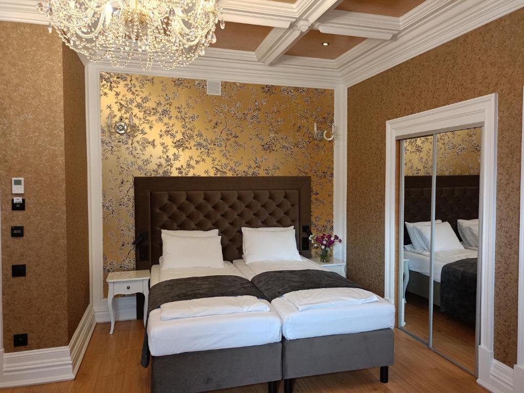 アウグストゥフにあるOficerski Yacht Clubのベッドルーム1室(ベッド2台、シャンデリア付)