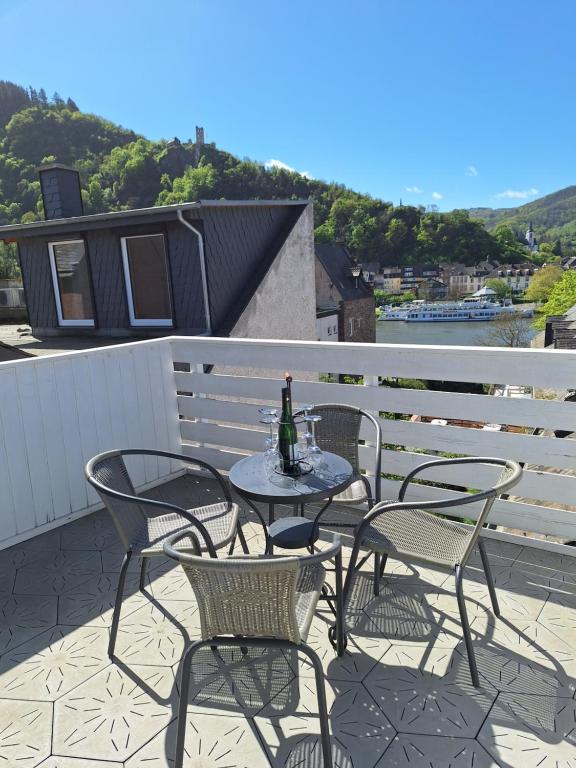 a table and chairs on a balcony with a bottle of wine at Ferienhaus Take it easy in Traben-Trarbach