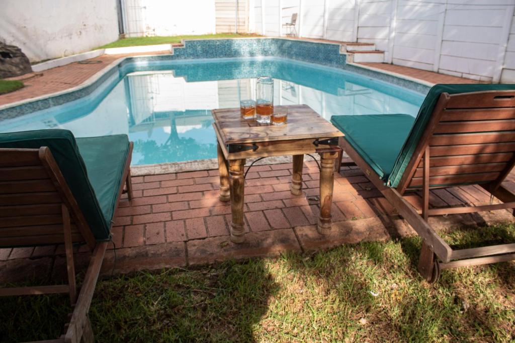 a table and chairs next to a swimming pool at Lux Lifestyle Forte’ in Johannesburg