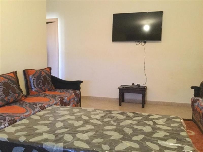 sala de estar con sofá y TV en la pared en Twins 11 Apartment, en Marrakech