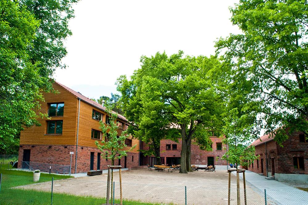 un edificio con un árbol delante de él en Umwelt Bildungszentrum Berlin en Berlín