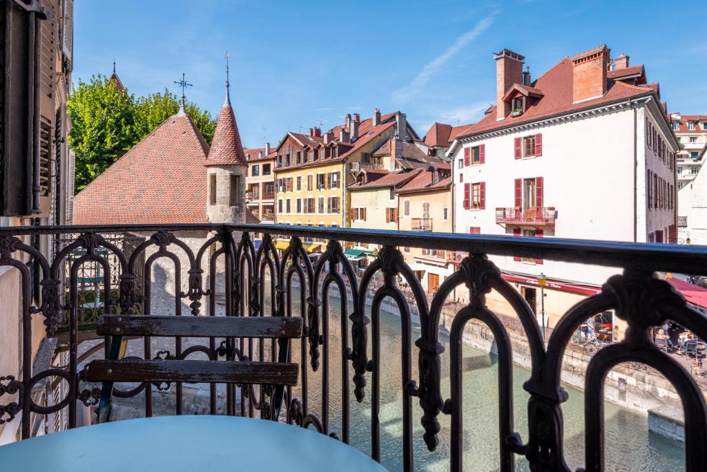 a bench sitting on a balcony overlooking a city at Hôtel du Palais de l'Isle in Annecy