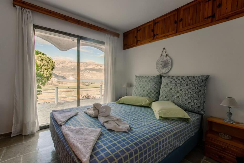 a bedroom with a bed with a teddy bear on it at Koriani Farm Cottage in Lixouri