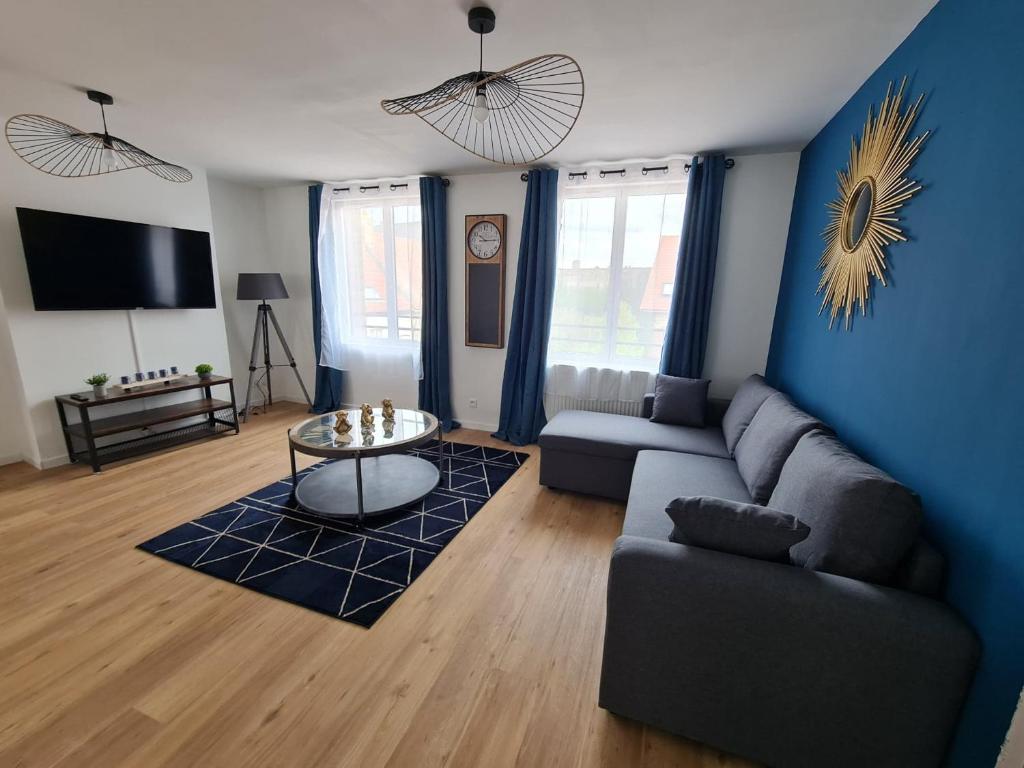 a living room with a couch and a table at Appartement spacieux pour 6 personnes in Saint-Omer