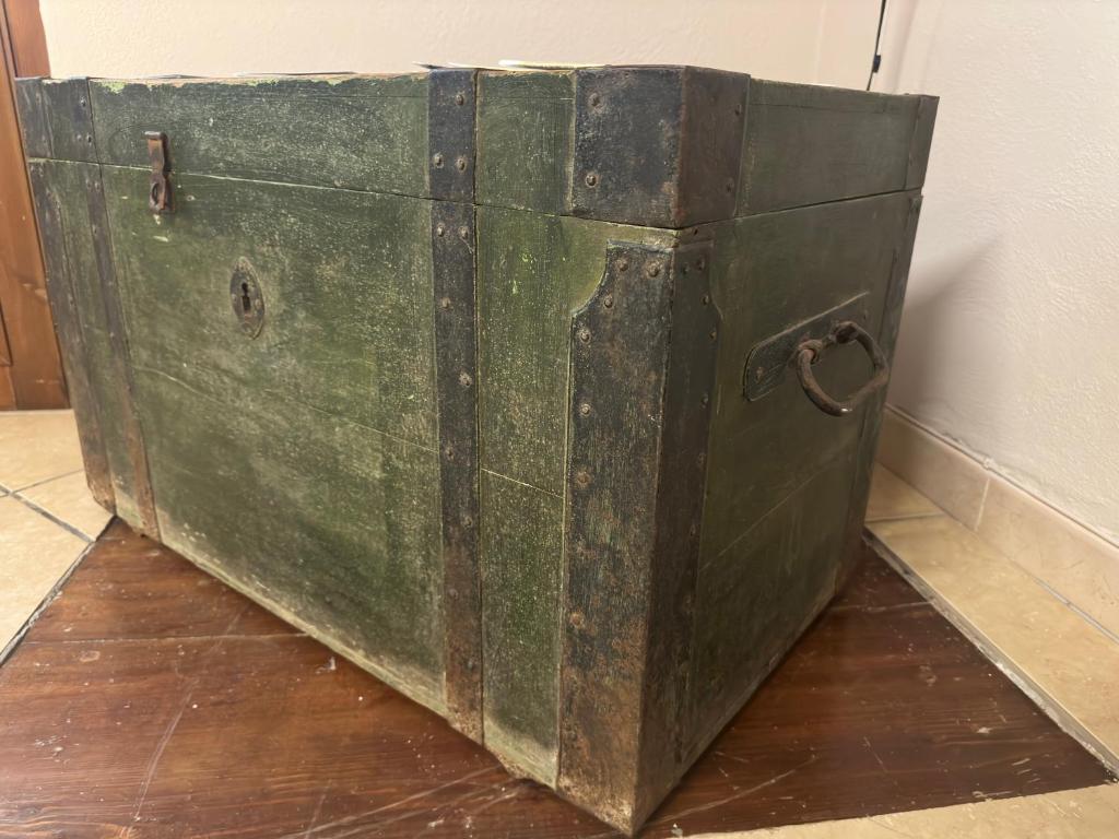 an old green chest sitting on a wooden floor at Lūǧārah - elegante loft in centro storico in Lucera