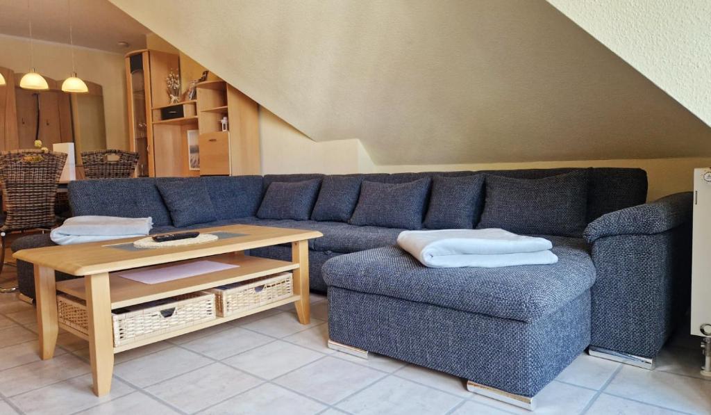 ein Wohnzimmer mit einem blauen Sofa und einem Tisch in der Unterkunft Ferienwohnung Möwennest in Kühlungsborn