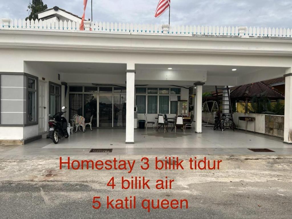 ein Haus mit einem Motorrad, das davor geparkt ist in der Unterkunft Kesuma Homestay Pantai Murni in Yan