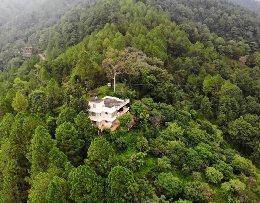 una vista aérea de una casa en medio de un bosque en The Umri Lansdowne, 4-bedroom homestay, en Lansdowne