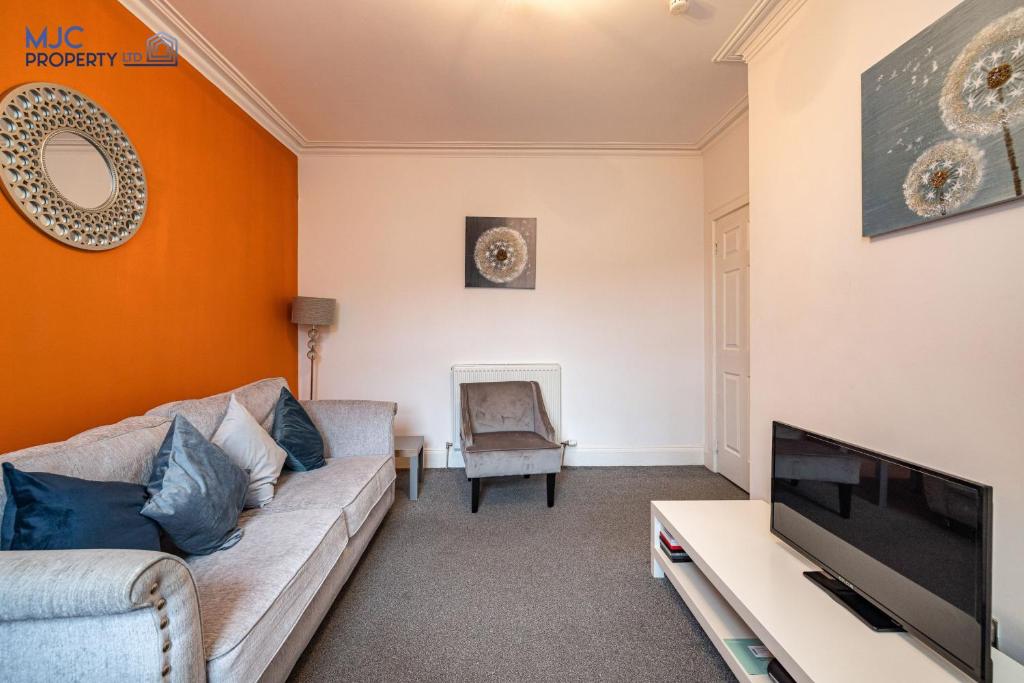 a living room with a couch and a tv at River Teviot in Hawick