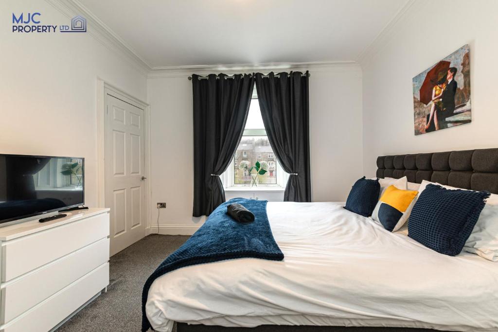 a bedroom with a large bed and a television at River Teviot in Hawick