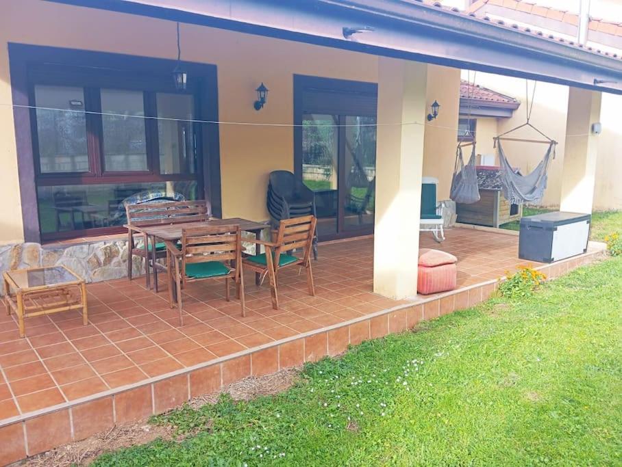 a patio with a table and chairs on a house at Los acebos. Mar, montaña, cuevas in Rasines