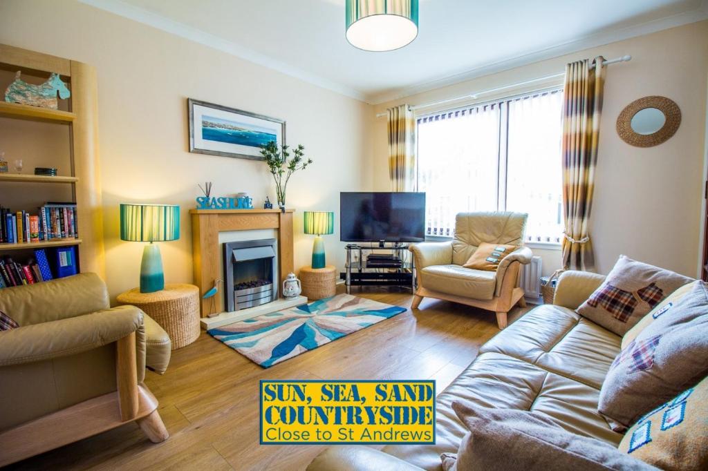 a living room with a couch and a tv at Beach House Walk - Crail - Home from Home in Crail