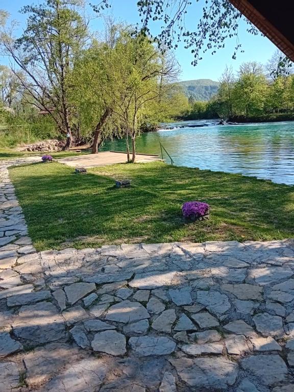 a stone walkway next to a body of water at Villa River and Sky in Bihać