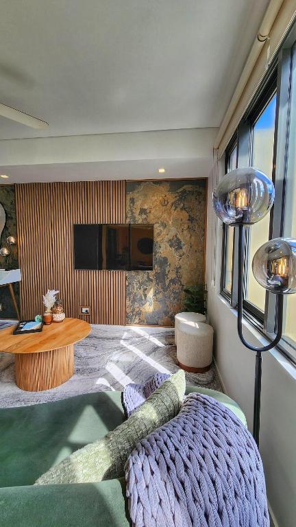 a bedroom with a bed and a table and a tv at Harbour-view Waterfront Apartment in Darwin