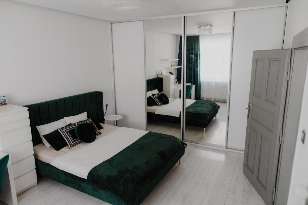 1 dormitorio con 1 cama grande y espejo en AH Zimná en Košice