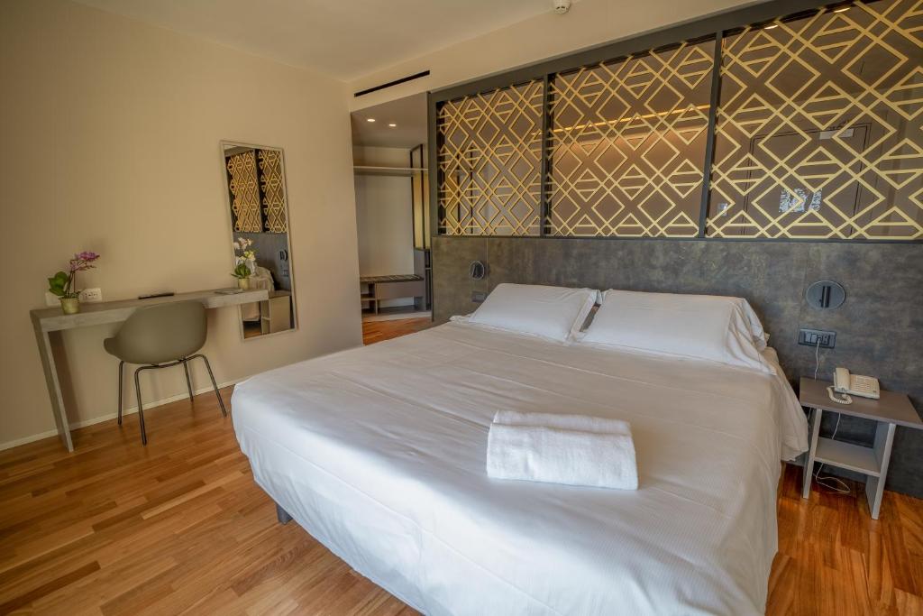 a bedroom with a large white bed and a table at Plaza Hotel Catania in Catania